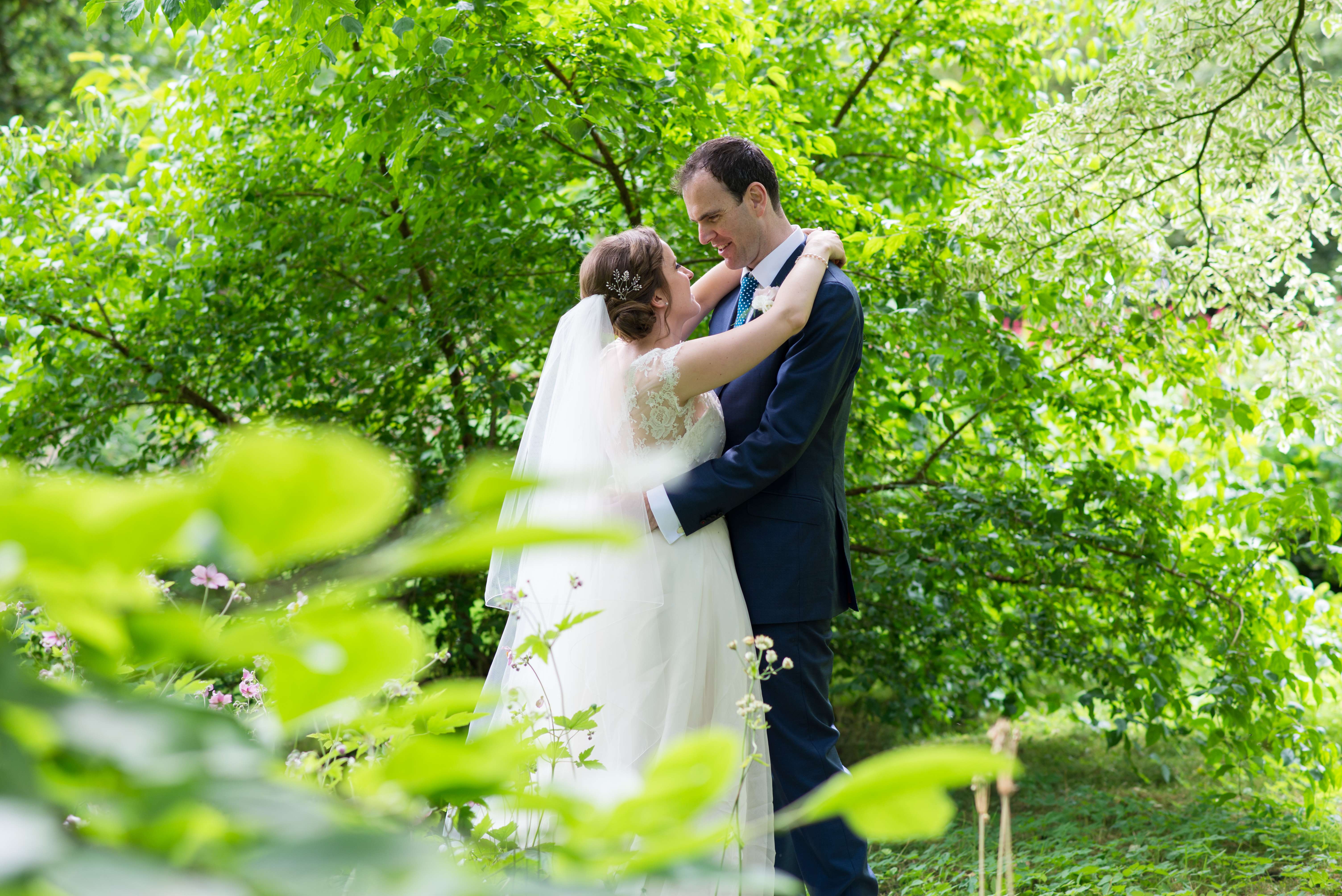 A newly married couple having their wedding photos taken in the garden of Kingston Bagpuize